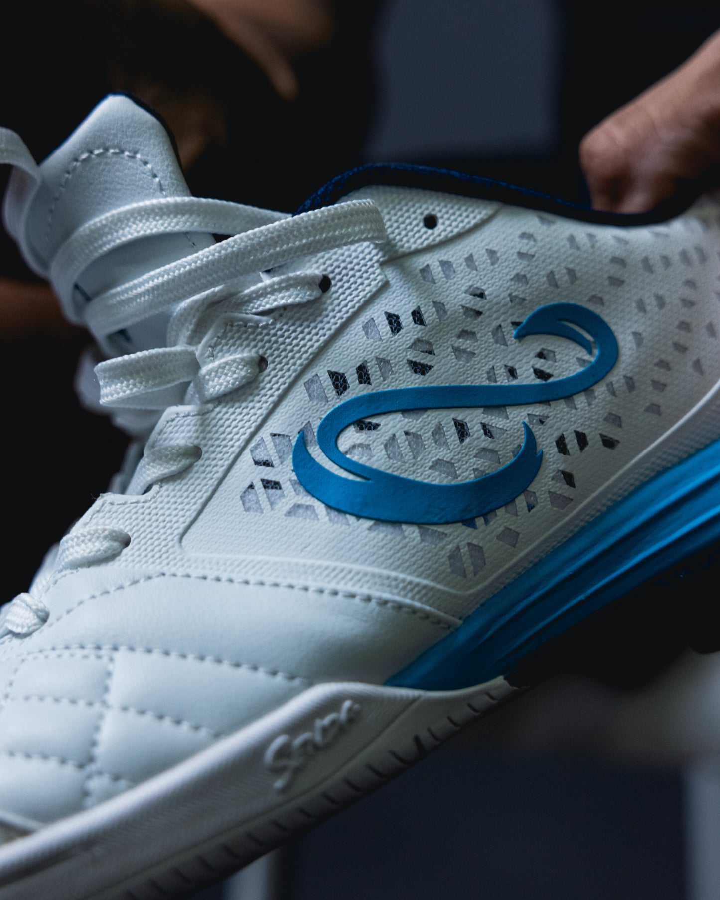 Side view of White Blue Ushuaia Pro 2.0 futsal shoe by SENDA, showcasing breathable perforated upper, bold logo detailing, and reinforced stitching for performance grip.