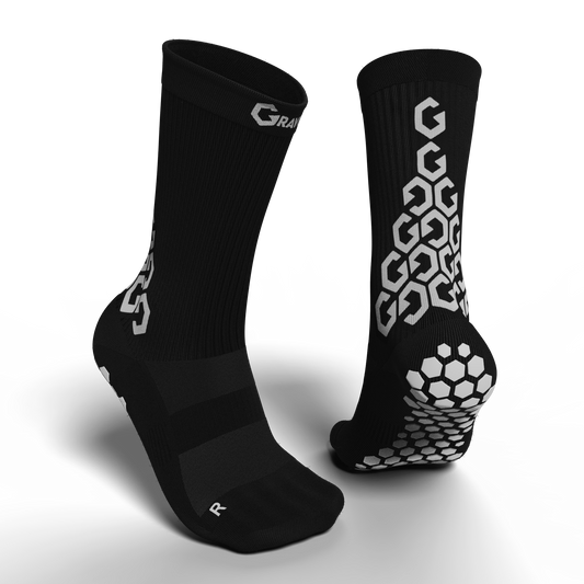Senda Gravity Pro Grip Socks in black shown from front and back, featuring cushioned compression upper and anti-slip hex grip pods for athletic performance.