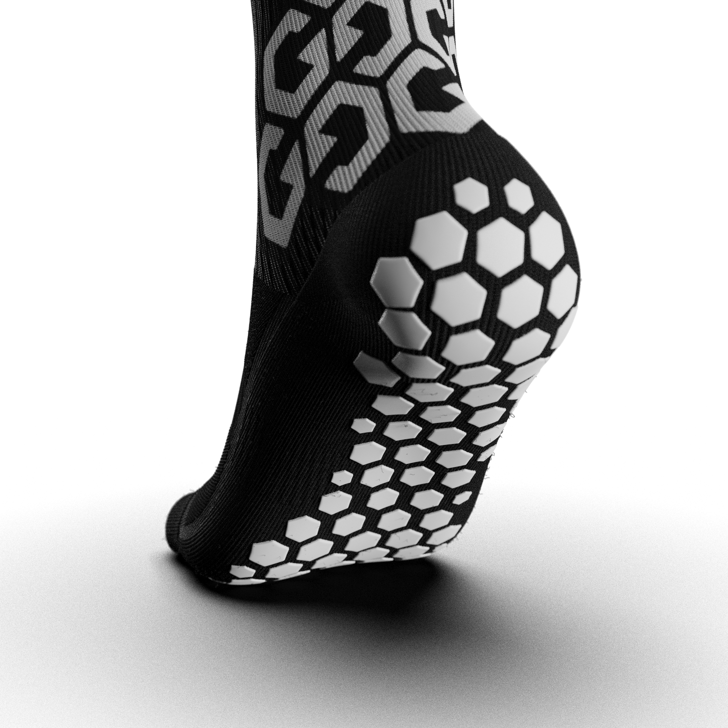 Close-up of the Senda Gravity Pro Grip Socks in black showing hexagonal anti-slip grip pods along the sole for enhanced traction and foot stability.