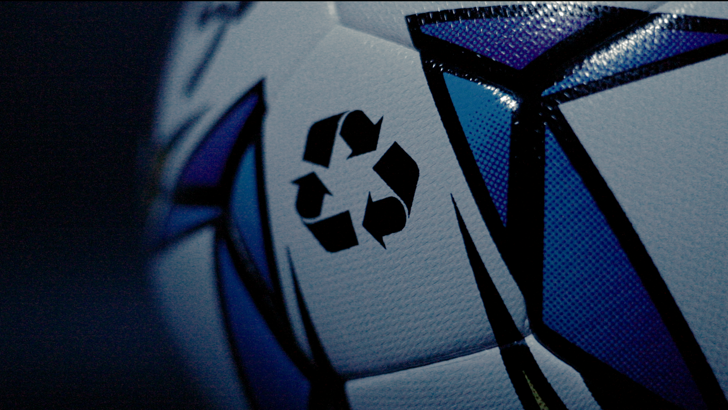 Macro shot of Senda Palmas Eco Futsal Ball highlighting recycled materials icon on multicolor geometric design.
