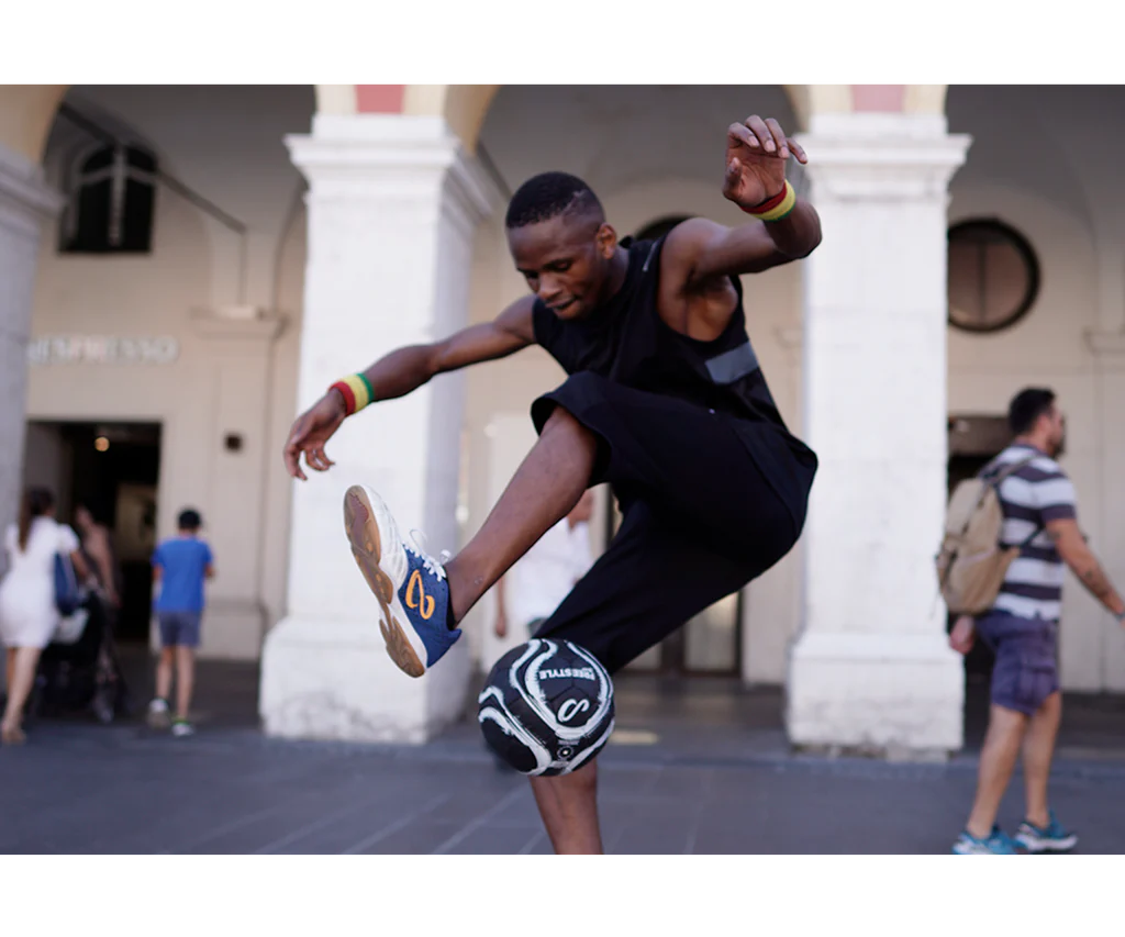 Freestyle athlete performing trick with Senda Street Freestyle Ball on blacktop, showcasing tire-like grip and low bounce control for urban play.