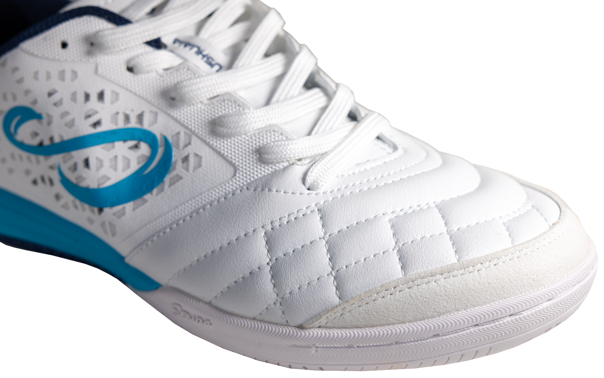 Close-up of white Ushuaia Club 2.0 futsal shoe by Senda, showing textured synthetic leather toe box with reinforced stitching and breathable mesh side panels.


