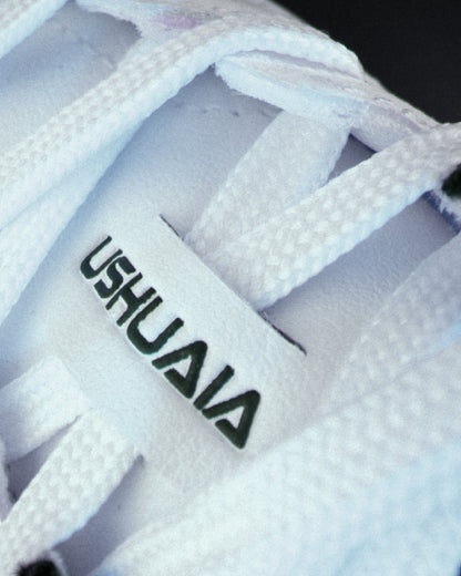 Detailed close-up of side logo on white Senda Ushuaia Pro 2.0 futsal shoe, showcasing breathable TPU upper and precise textured paneling for enhanced durability.

