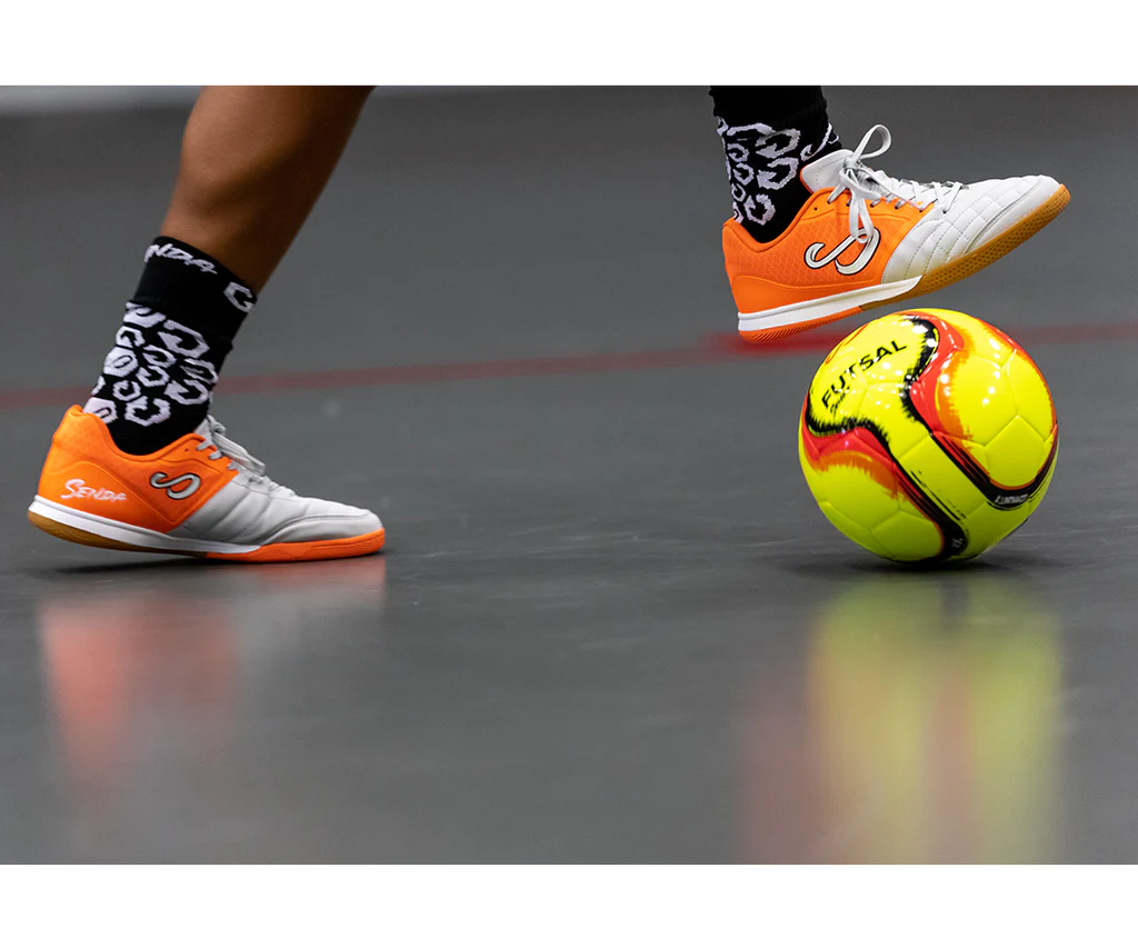 Player controlling Yellow Belem Training Futsal Ball by Senda – Low-bounce indoor futsal ball in motion on hard court, ideal for close control and training performance.


