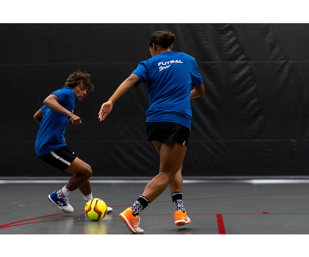 Players competing with Yellow Belem Training Futsal Ball by Senda – Indoor futsal game featuring Fair Trade Certified low-bounce ball designed for control and agility on hard courts.

