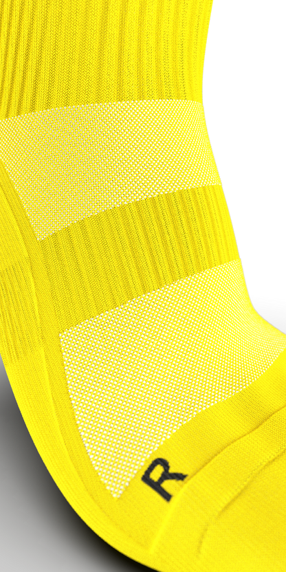 Close-up of Senda Gravity Pro yellow crew sock showing breathable knit zones and arch support compression.

