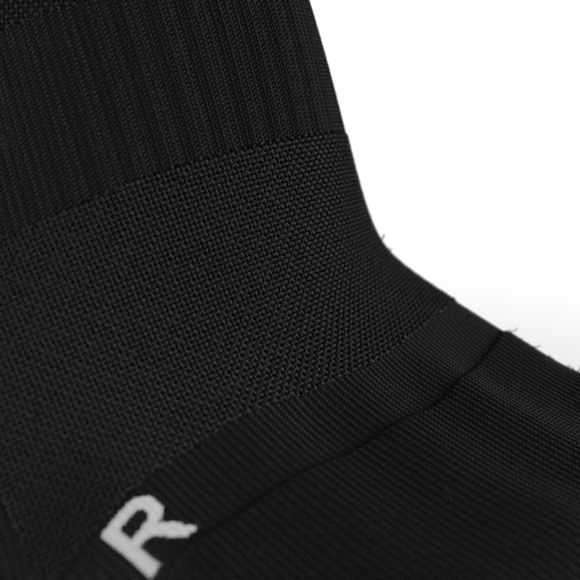 Detailed close-up of the arch support compression band on the Senda Gravity Pro Grip Socks in black, designed for stability and comfort during play.

