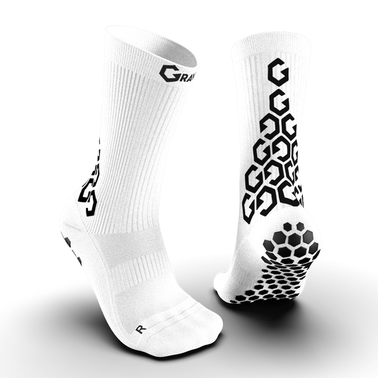 Senda Gravity Pro Grip Socks in white shown from front and back, highlighting moisture-wicking mesh zones, grip hex pods, and bold G logo branding.

