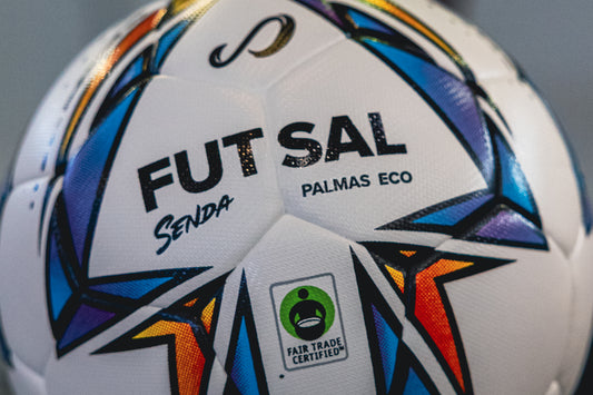 Close-up of Senda Palmas Eco Futsal Ball showing bold FUTSAL lettering and Fair Trade Certified logo on white textured panels.

