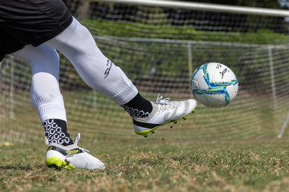 Soccer player striking a ball while wearing Senda Pampa Pro Soccer Cleats, highlighting stud traction and dynamic movement on the field.


