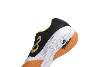 Close-up heel view of Senda Ushuaia Club 2.0 white futsal shoe highlighting black mesh upper and grippy gum outsole.


