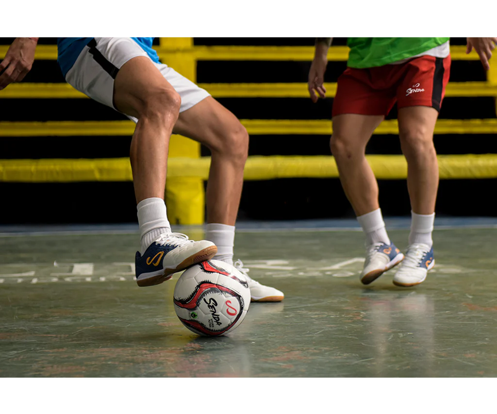 Senda Vitoria Premium Match Futsal Ball in red used in a competitive indoor court match, showcasing control and durability in tight play.

